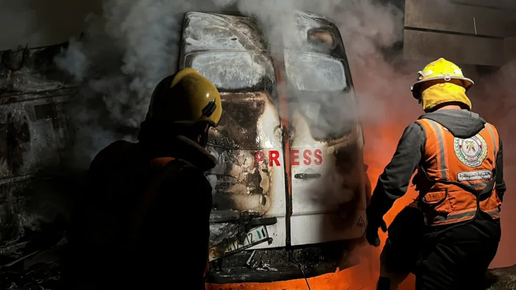 Civil Defense members put out a fire in a broadcast van following an Israeli strike that killed five Palestinian journalists, (Reuters photo)